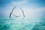 Tranquil hammock hanging over idyllic blue ocean, Maldives, Indian Ocean