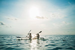 Women in clear bottom canoe on sunny, idyllic ocean, Maldives, Indian Ocean