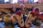 Portrait happy family in colorful socks relaxing in Christmas living room