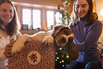 Mother and daughter playing with dog in Christmas gift box