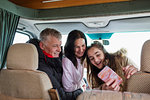 Happy family with smart phone taking selfie in motor home