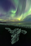 Northen Lights over block of ice in Jokulsarlon Glacier Lagoon, Austurland, Eastern Iceland, Iceland, Europe