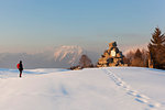 A hiker observes the partisan tombstone on Costa Mount, Prealps of Belluno, Farra d'Alpago, Belluno province, Veneto, Italy