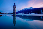 The bell-tower of Graun in Vinschgau at dusk, Reschensee - Lago di Resia, Bolzano, South Tyrol, Trentino Alto Adige, Italy