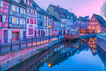 Canal waterfront view of traditional townhouses at dusk, Colmar, France