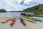 Kayaks on the shore of Lake Mapourika. Waiho, Westland district, West Coast region, South Island, New Zealand.