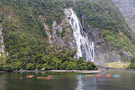 People kayaking around Bowen Falls in Milford Sound in summer. Fiordland NP, Southland district, Southland region, South Island, New Zealand.