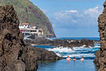 Three men bathing in the natural pools of Porto Moniz, Madeira region, Portugal.