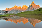 Enrosadira on Pale di San Martino Dolomites reflecting on the lake of Segantini hut, Rolle Pass, Trento province, Trentino Alto Adige, Italy