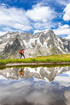 A trekker is walking on the Mont de la Saxe in front of Grandes Jorasses during the Mont Blanc hiking tours (Ferret Valley, Courmayeur, Aosta province, Aosta Valley, Italy, Europe) (MR)