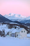 Sunrise on typical house with Lyngen Alps in the background, Mestervik, Troms county, Norway