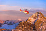 Aerial view of helicopter in flight towards Pizzo Scalino at sunset, Valmalenco, Valtellina, Lombardy, Italy