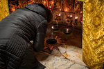 Pilgrim praying at the birthplace of Jesus Christ marked with a fourteen-point silver star, the Altar of the Nativity, Church of the Nativity, Bethlehem, Palestine, Middle East