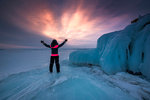 A person with rised hands at sunrise at lake Baikal, Irkutsk region, Siberia, Russia