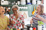 Happy active senior women cooking in kitchen
