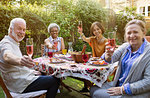 Portrait smiling, confident active senior friends drinking rose wine and enjoying lunch at patio table