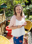 Portrait confident senior woman using smart phone on sunny patio