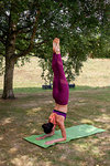 Woman practicing yoga in garden, forearm stand