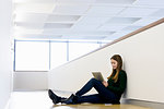 Woman sitting on floor using digital tablet