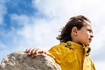 Boy beside rock with breeze in hair