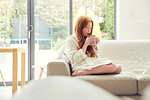 Girl having warm drink on sofa