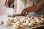 Woman cutting dough for gnocchi