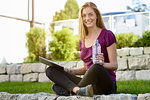 Young woman using digital tablet in park