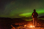 Man watching aurora borealis, Narsaq, Vestgronland, Greenland