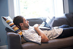 Man using laptop on sofa