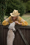 Woman playing with pet dog in garden