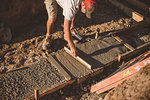Builder laying cement foundation