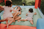 Mother and daughters playing on bouncy castle