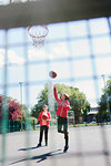 Active senior women playing basketball in sunny park