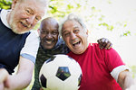 Portrait active senior men friends playing soccer