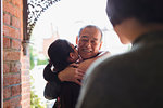 Granddaughter hugging, greeting granddaughter at front stoop