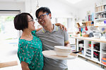 Affectionate couple hugging, doing dishes in kitchen