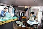 Japanese male and female fashion designers working in a studio.