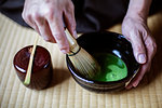 High angle close up of traditional Japanese Tea Ceremony, man using bamboo whisk to prepare Matcha tea.