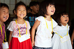 Group of girls and boys wearing name tags singing together in a temple.