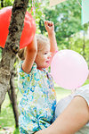 Girl holding balloon in her mother's arms
