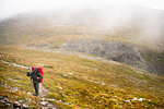 Man hiking up a hill at Pallas-Yllastunturi National Park in Lapland, Sweden
