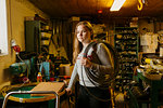 Teenage girl holding coil of rope in rope maker shop