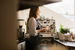 Barista holding coffee in cafe kitchen