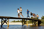 Group of teenagers running across jetty