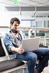 Man using laptop in airport waiting area