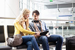 Couple using tablet computer in airport