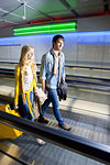 Couple on moving walkway in airport