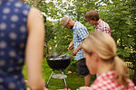 Men grilling fish on barbecue outdoors