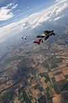 People skydiving over rural landscape