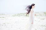Young woman with long windswept black hair on beach